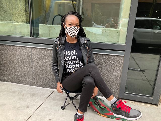 Shanette Charles wears a shirt that has the first names of Antron McCray, Kevin Richardson, Raymond Santana, Korey Wise, Yusef Salaam